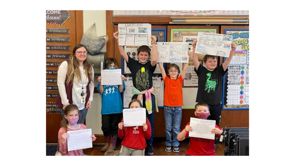 Students showing polar bear posters