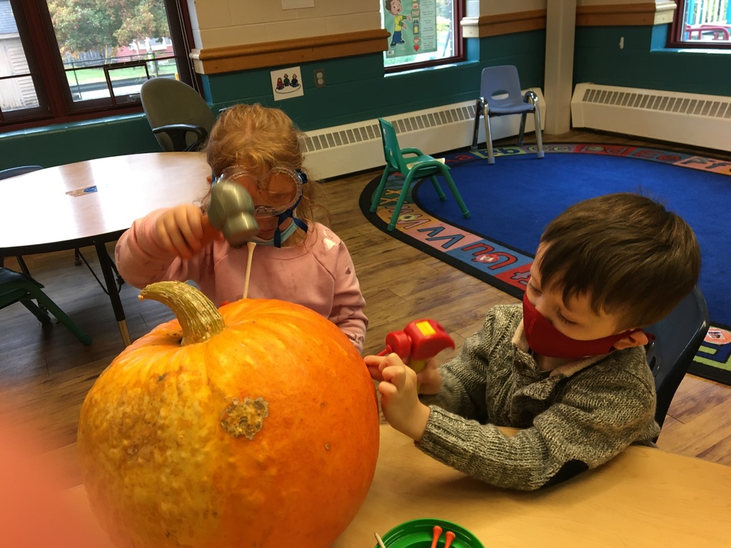 two students decorating a pumpkin