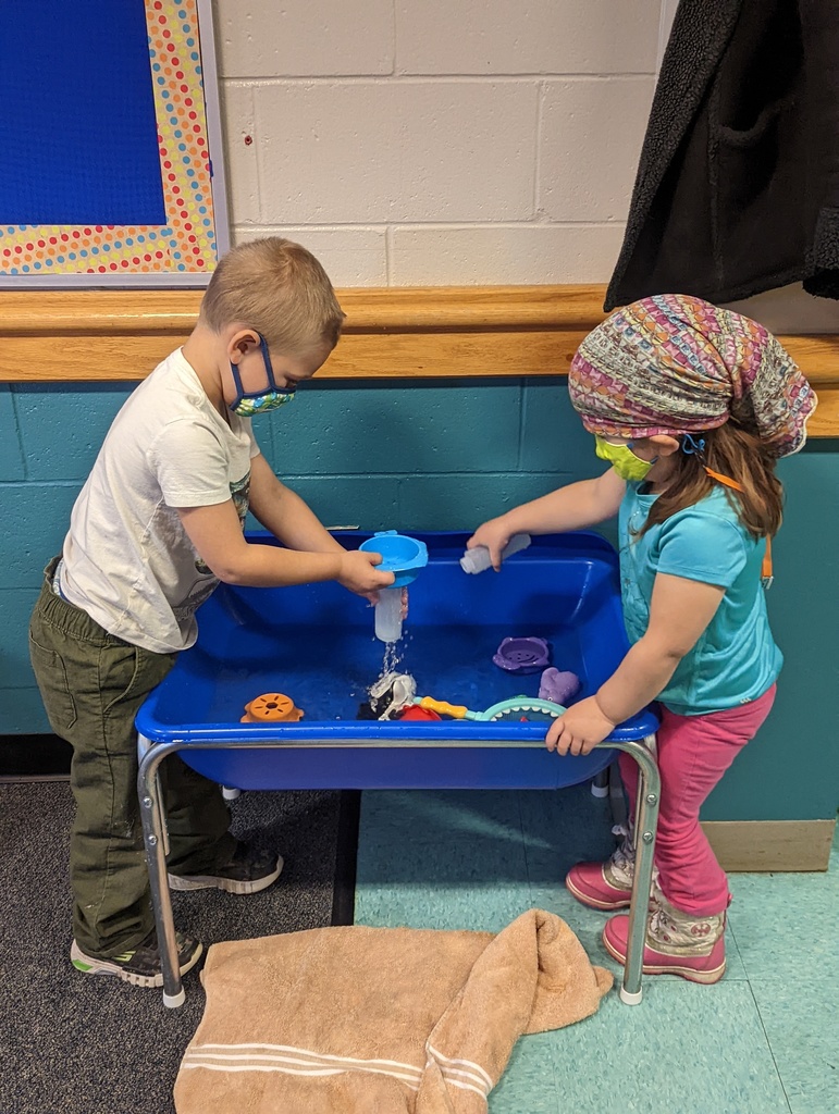 Two children playing in the water table