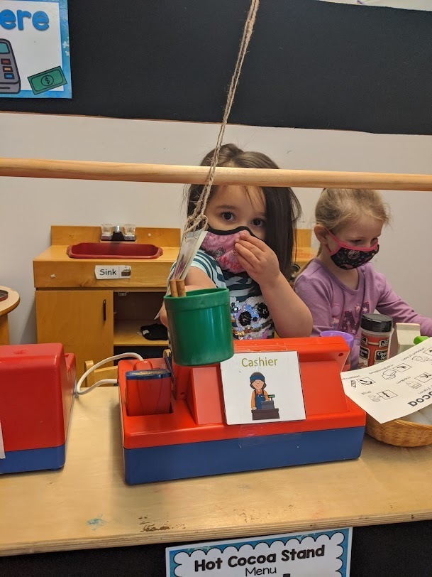 two students making hot chocolate in the dramatic play area
