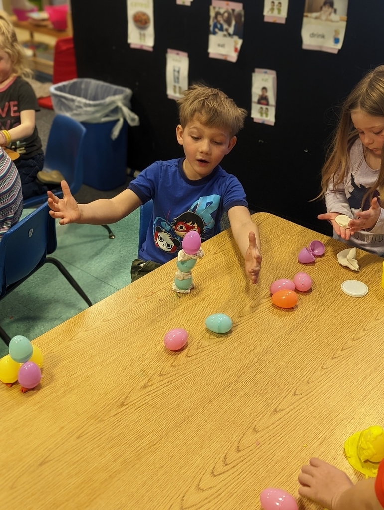preschool boy stacking plastic Easter eggs
